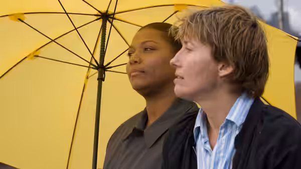 Karen Eiffel (Emma Thompson) and Penny Escher (Queen Latifah) under a yellow umbrella