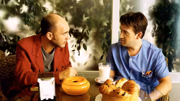 Marco (Darío Grandinetti) and Benigno (Javier Cámara) talking at a breakfast table
