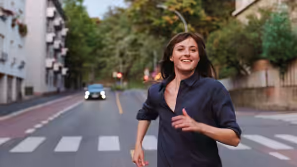 Julie (Renate Reinsve) runs across a city street toward the camera
