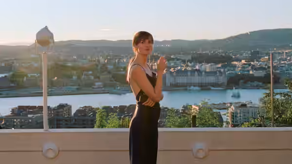 Julie (Renate Reinsve) stands on a terrace overlooking the city and waterfront