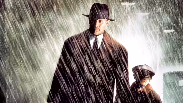 Michael Sullivan (Tom Hanks) and his son walking together in pouring rain