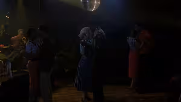 Couples dance on a dimly lit dance floor with a live band