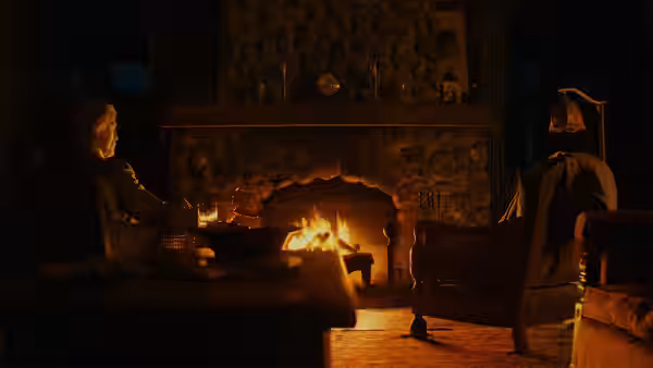 Martha Delacroix (Glenn Close) seated by a fireplace at night
