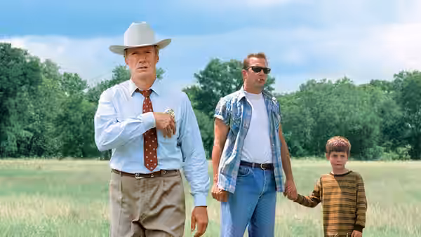 Chief Red Garnett and Butch Haynes walk through a field with Phillip