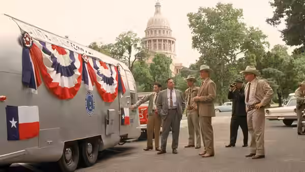 Lawmen gather beside a bunting-decorated trailer beneath the Texas Capitol