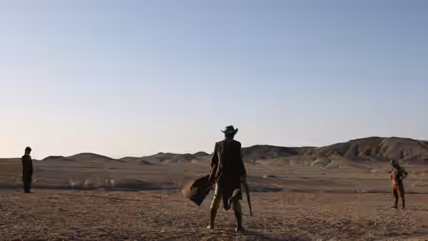 Three armed men face one another across a barren desert plain