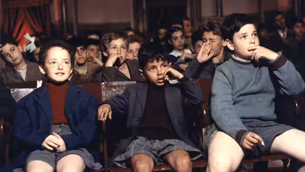 Young Totò and other boys seated in a cinema audience