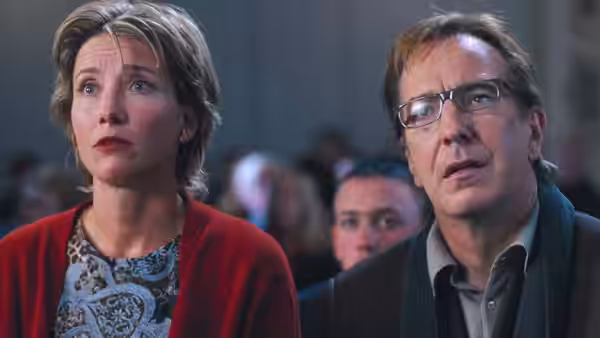 Karen (Emma Thompson) and Harry (Alan Rickman) seated with concerned expressions