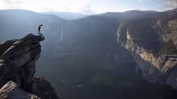 Alex Honnold perched on a cliff edge overlooking a vast canyon