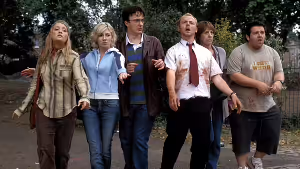 Shaun (Simon Pegg) and a group walking outdoors with blood on their clothes