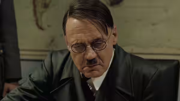Adolf Hitler (Bruno Ganz) in glasses and leather coat looking down