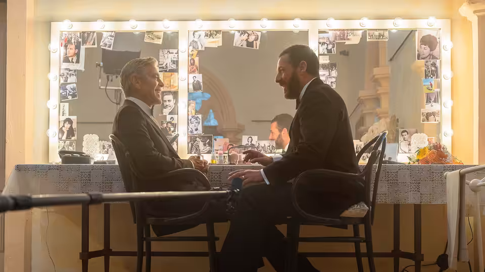 Jay Kelly (George Clooney) and Ron Sukenick (Adam Sandler) talking in a dressing room