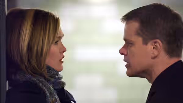 Jason Bourne (Matt Damon) standing face to face with a blonde woman