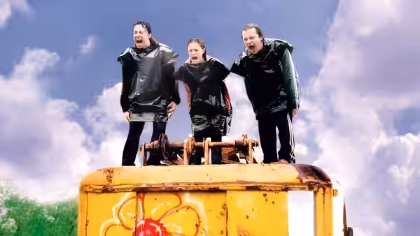 Sam (Natalie Portman) on a yellow vehicle with two men in rain gear