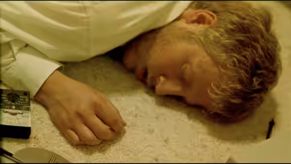 Aaron (Shane Carruth) lying unconscious on a carpeted floor