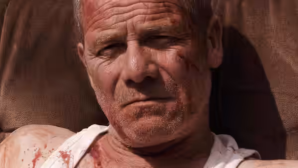 Joseph (Peter Mullan) with a bruised bloody face lying down