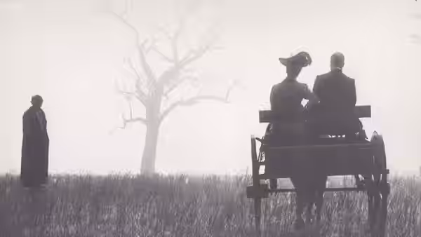 A lone figure watches two people riding a horse-drawn cart across a grassy field