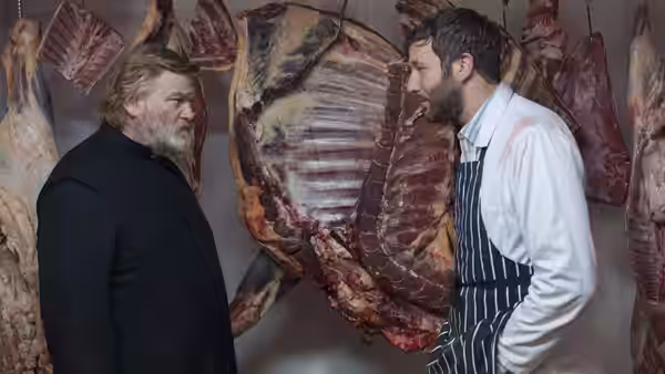 Father James (Brendan Gleeson) confronting a butcher amid hanging carcasses