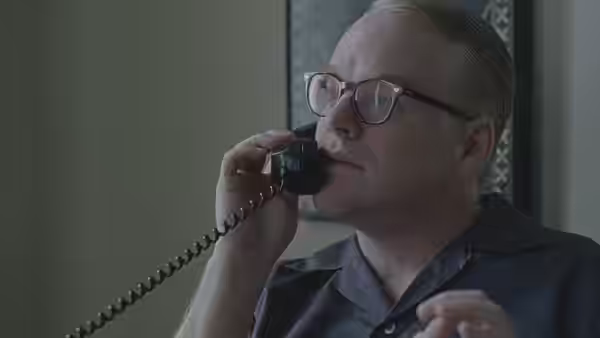 Truman Capote (Philip Seymour Hoffman) speaking on a telephone