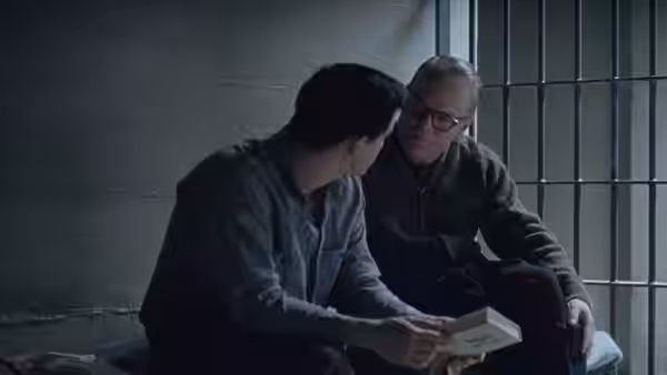 Truman Capote (Philip Seymour Hoffman) and Perry Smith (Clifton Collins Jr.) reading in a prison cell