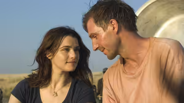 Tessa Quayle (Rachel Weisz) and Justin Quayle (Ralph Fiennes) gazing closely at each other outdoors