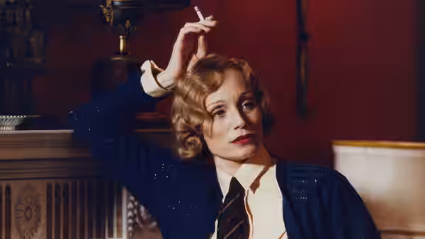 blonde woman in blue sequined jacket holds cigarette above her head