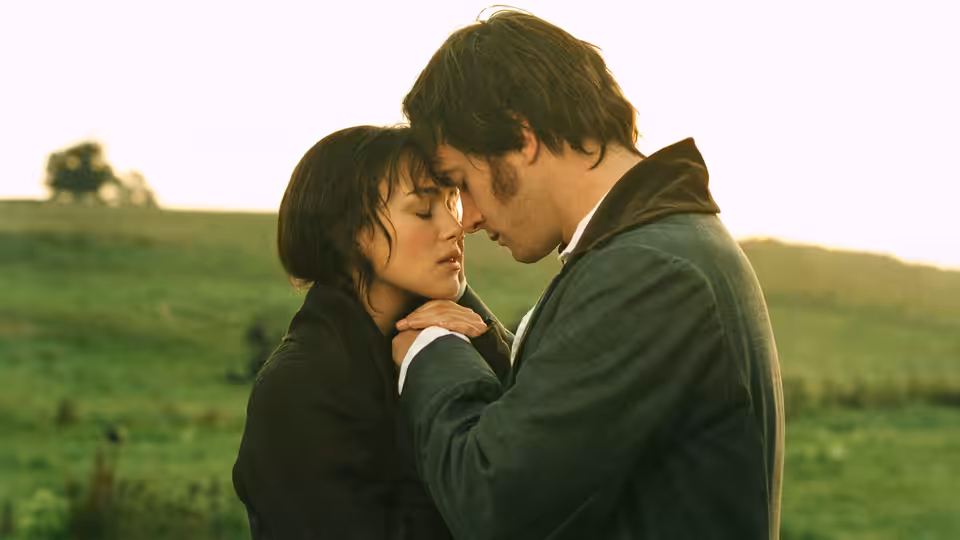 Elizabeth Bennet (Keira Knightley) and Mr. Darcy (Matthew Macfadyen) embracing in an open field