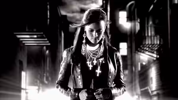 Woman with long dark hair wearing crosses on a nighttime street