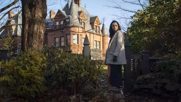 Marta Cabrera standing outside the mansion near the front gate