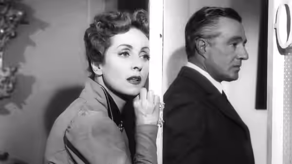 Comtesse Louise de... (Danielle Darrieux) peers around a doorway as a man stands beside her