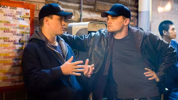Colin (Matt Damon) talking to Billy (Leonardo DiCaprio) near a phone booth