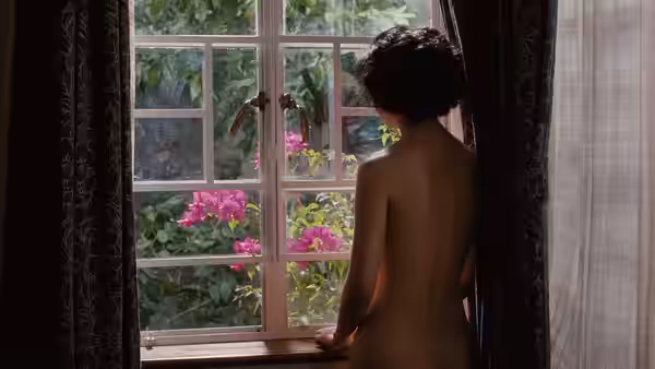 Wong Chia Chi (Tang Wei) stands nude at a window overlooking a garden