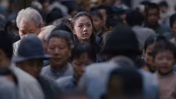 Wong Chia Chi (Tang Wei) looks ahead while surrounded by a crowded street
