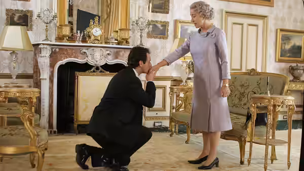 Tony Blair (Michael Sheen) kneeling to kiss the hand of Queen Elizabeth II (Helen Mirren)