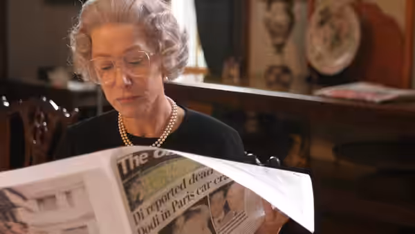 Queen Elizabeth II (Helen Mirren) reading a newspaper about the Paris car crash