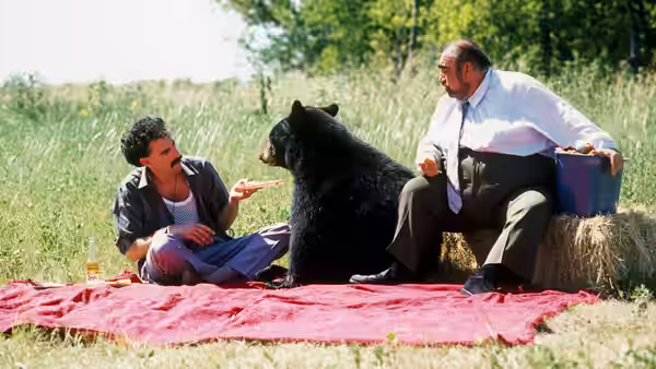 Borat (Sacha Baron Cohen) and Azamat (Ken Davitian) with a bear on a blanket