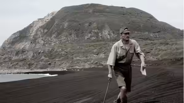 General Tadamichi Kuribayashi walking on black sand holding papers