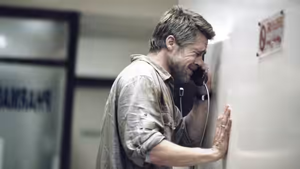 Richard Jones (Brad Pitt) speaks on the phone in a corridor