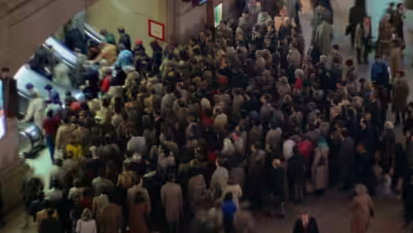dense crowd of people filling a busy indoor public concourse