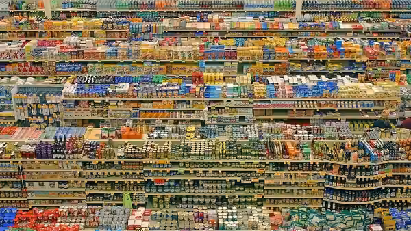 aisles of colorful packaged products stacked on supermarket shelves