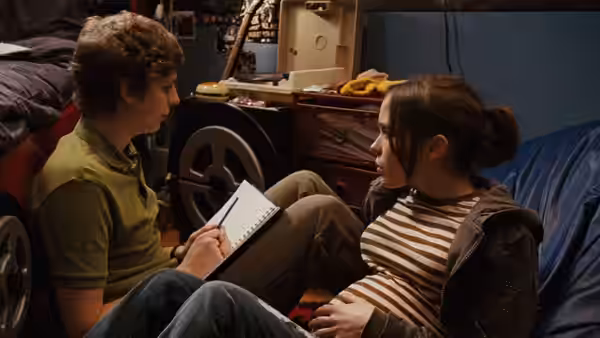 Paulie Bleeker (Michael Cera) sitting with Juno (Elliot Page) holding a notebook