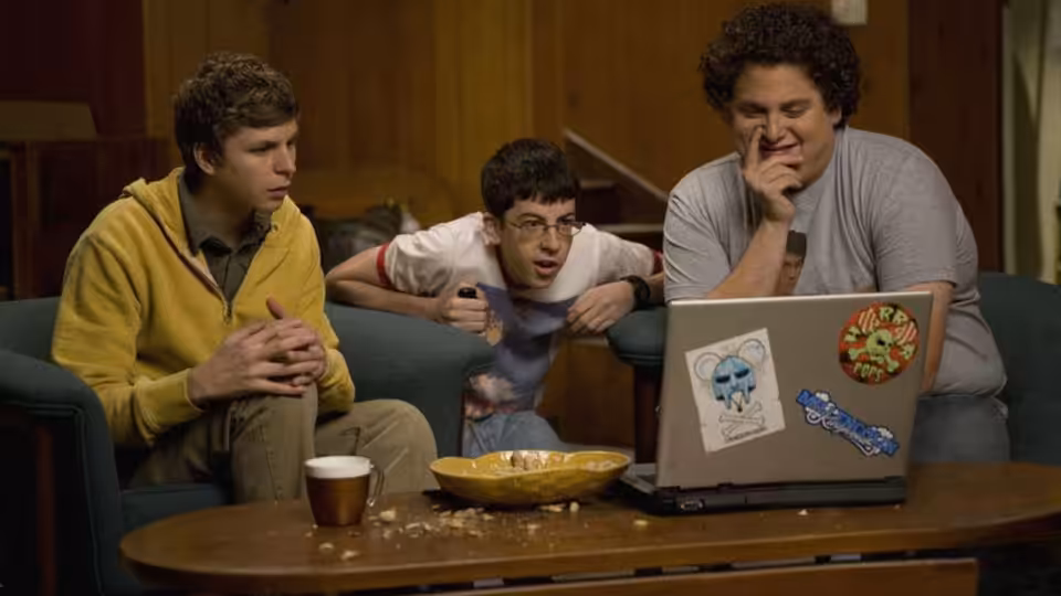 Seth (Jonah Hill) Evan (Michael Cera) and Fogell (Christopher Mintz-Plasse) looking at a laptop on the couch