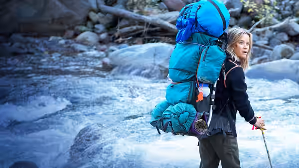 Cheryl Strayed (Reese Witherspoon) wading through a rushing river with backpack