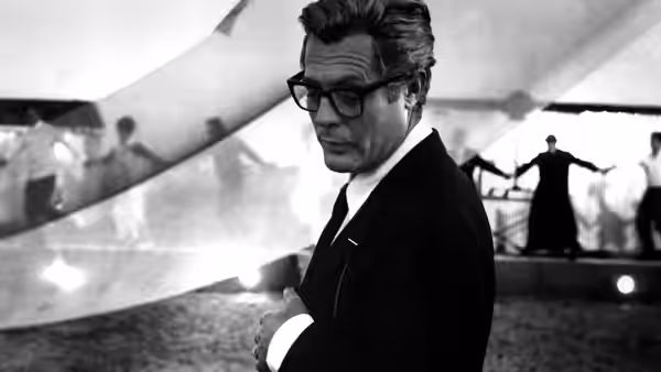 Guido Anselmi (Marcello Mastroianni) standing with arms crossed on a film set