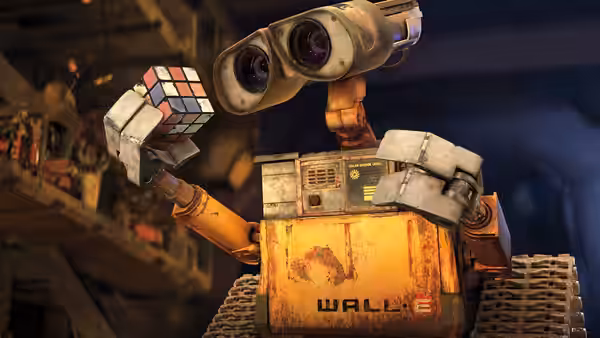 WALL·E holding a Rubik's cube in a cluttered workshop