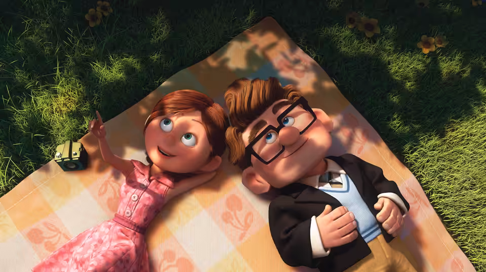 Young Carl and young Ellie lying on a picnic blanket in the grass