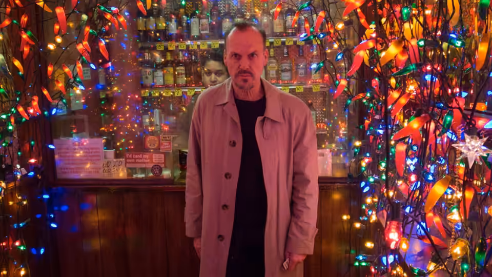 Riggan (Michael Keaton) standing in a bar surrounded by colorful lights
