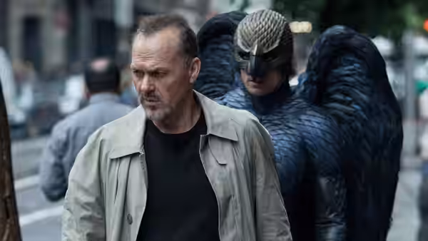 Riggan (Michael Keaton) walking beside a man in a bird costume