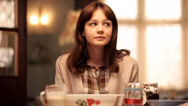 Jenny (Carey Mulligan) sits at a table with bowls and glasses before her
