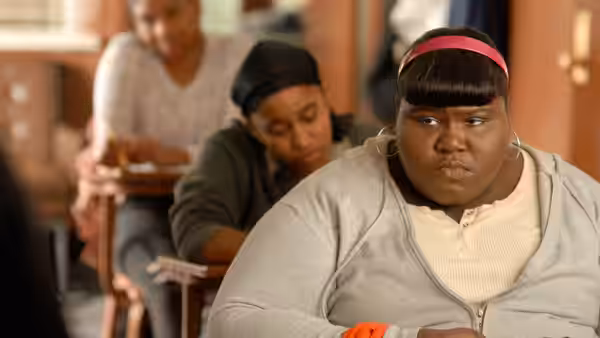 Precious (Gabourey Sidibe) sits in a classroom looking ahead intently